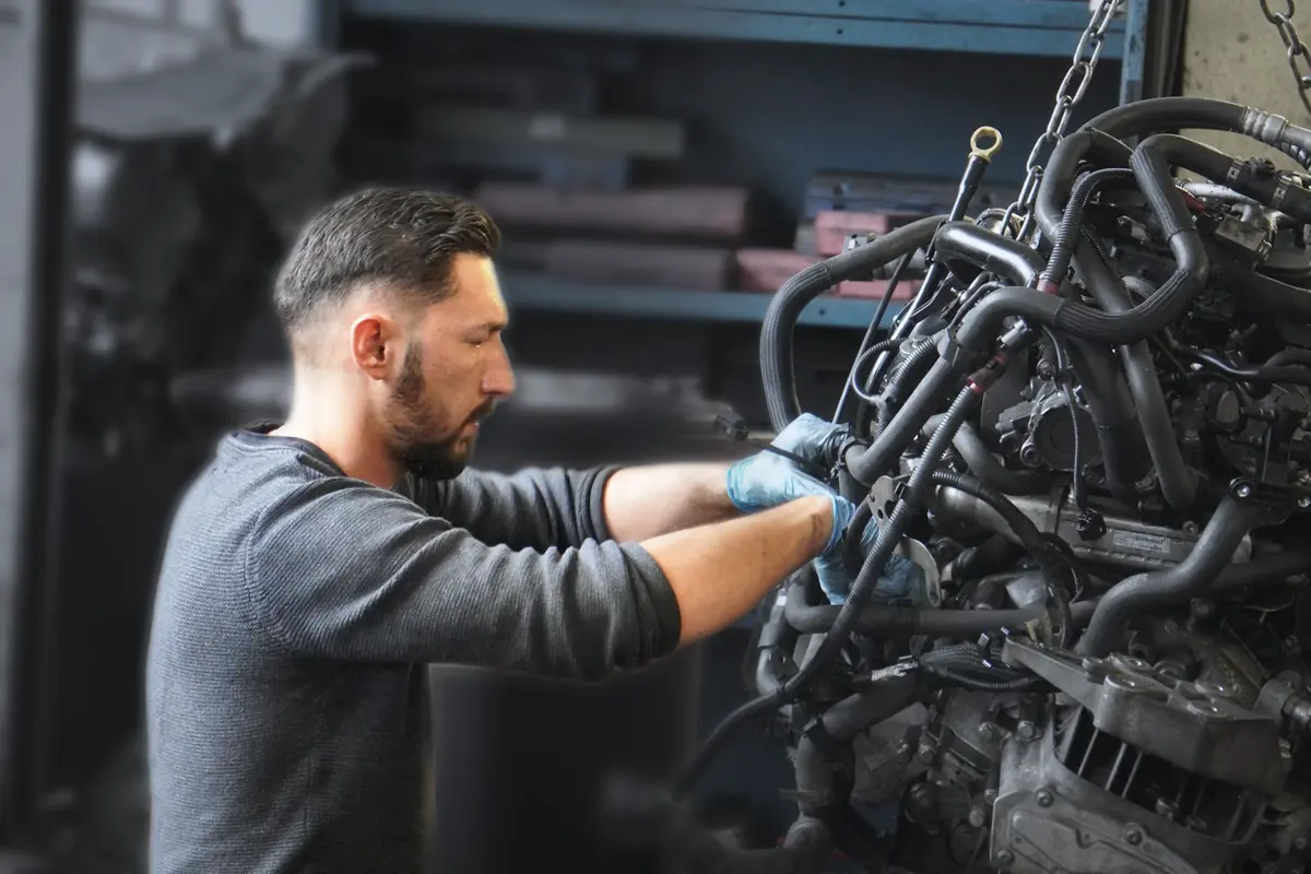 Mechaniker arbeitet an einem ausgebauten Motor
