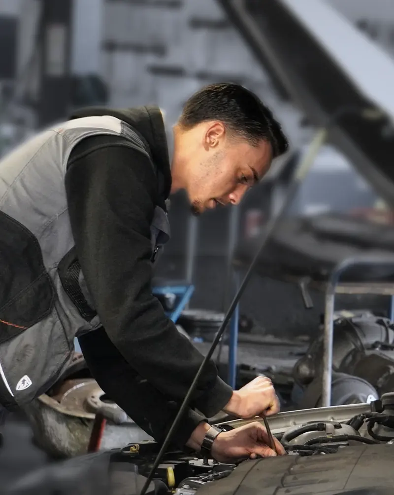 Mechaniker arbeitet unter der geöffneten Motorhaube
