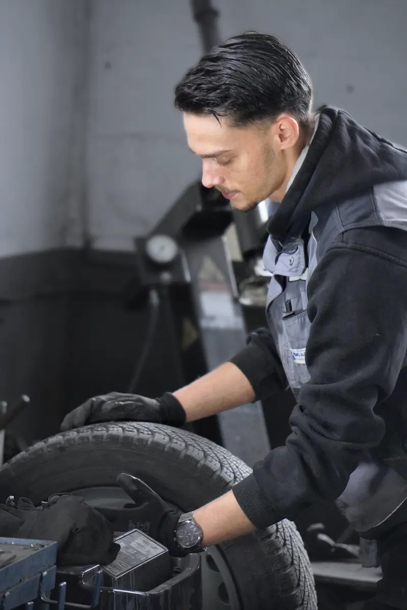 Mechaniker an der Reifenmontiermaschine